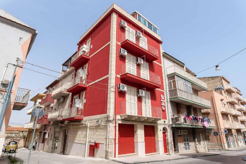 um edifício vermelho na esquina de uma rua em La dimora del monsignore em Licata