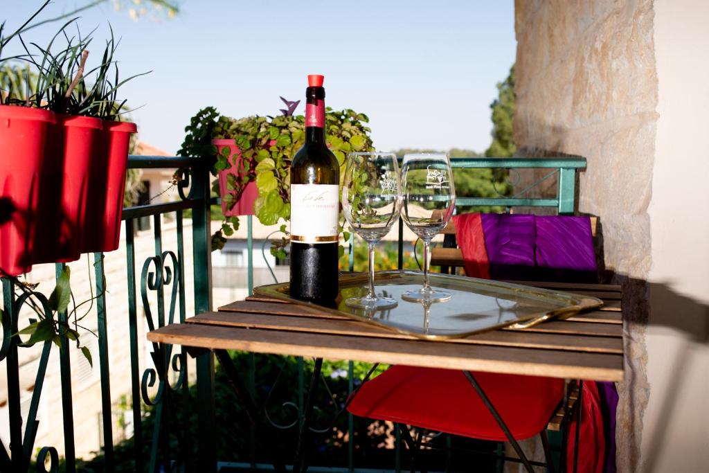una botella de vino sentada en una mesa con copas de vino en Erella's, en Rosh Pina