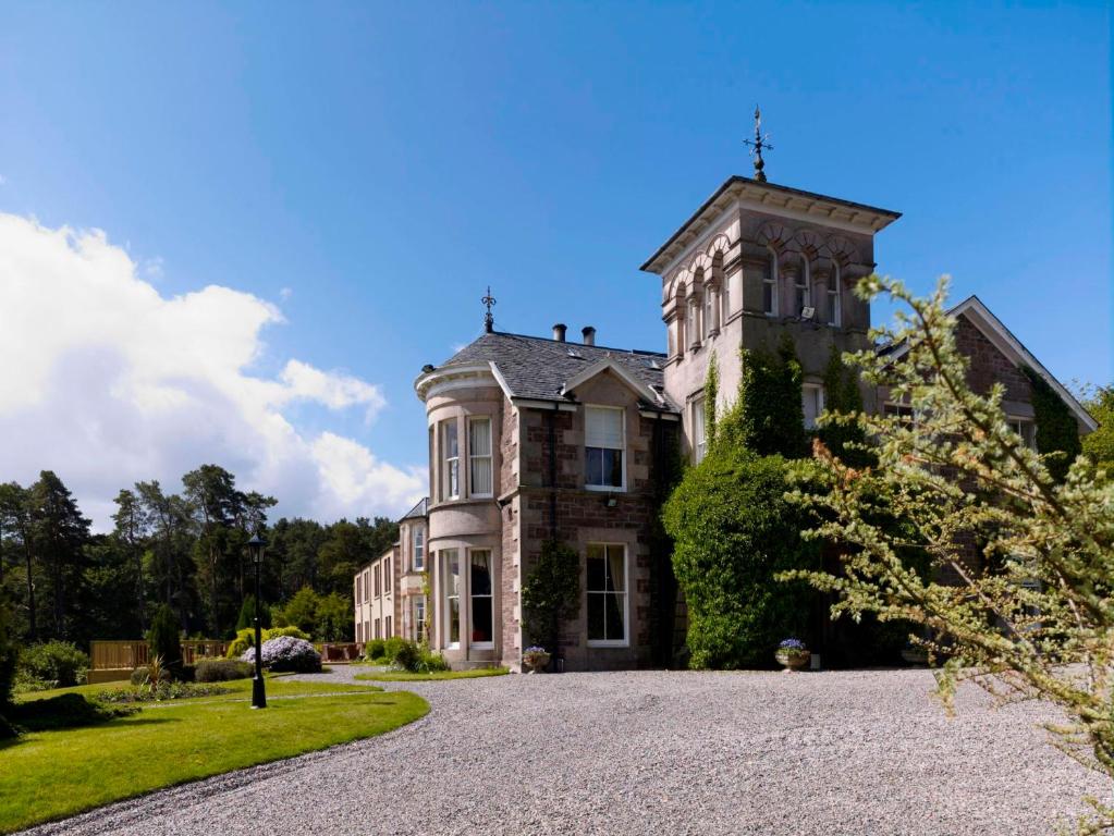 a large house with a tower on top of it at Loch Ness Country House Hotel in Inverness