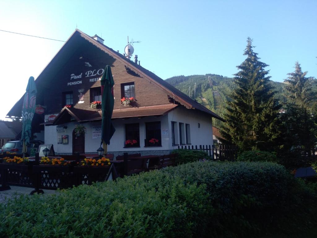 un edificio con una casa con flores delante en Pension Ploc en Harrachov