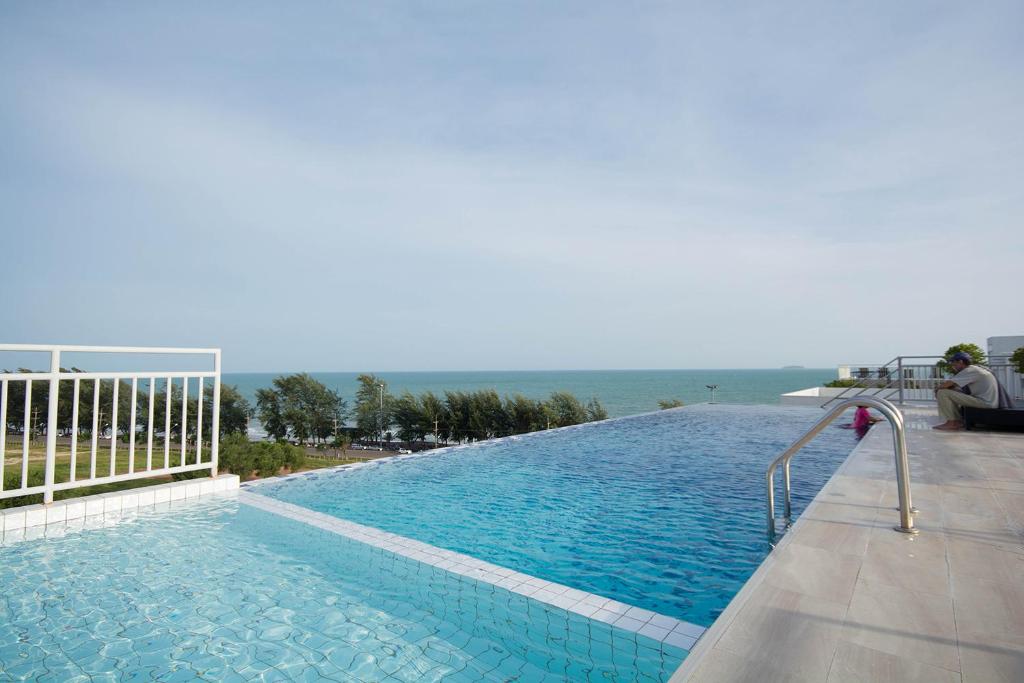 a large swimming pool with the ocean in the background at Mosaic Condminum A24m by malai in Mae Pim