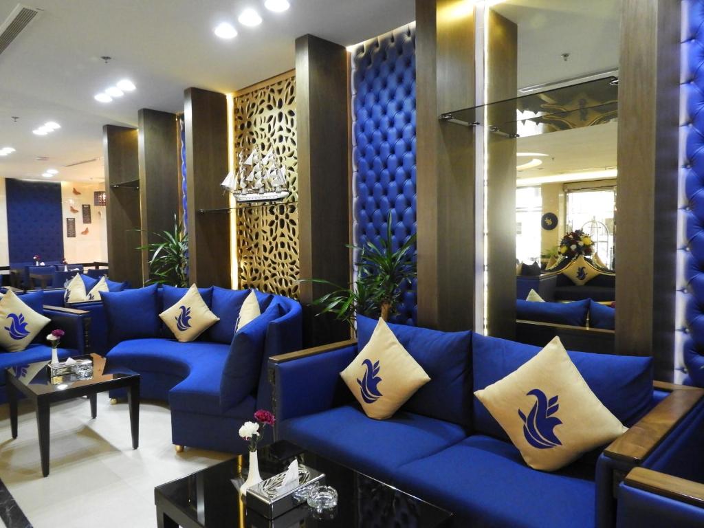 a living room with blue couches and a blue couch at Swiss Blue Hotel Al Zahra in Jeddah
