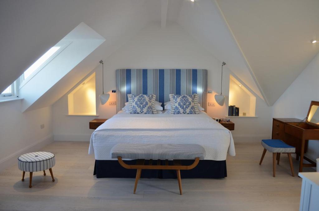 a bedroom with a large bed with blue and white pillows at Trevose Harbour House in St Ives