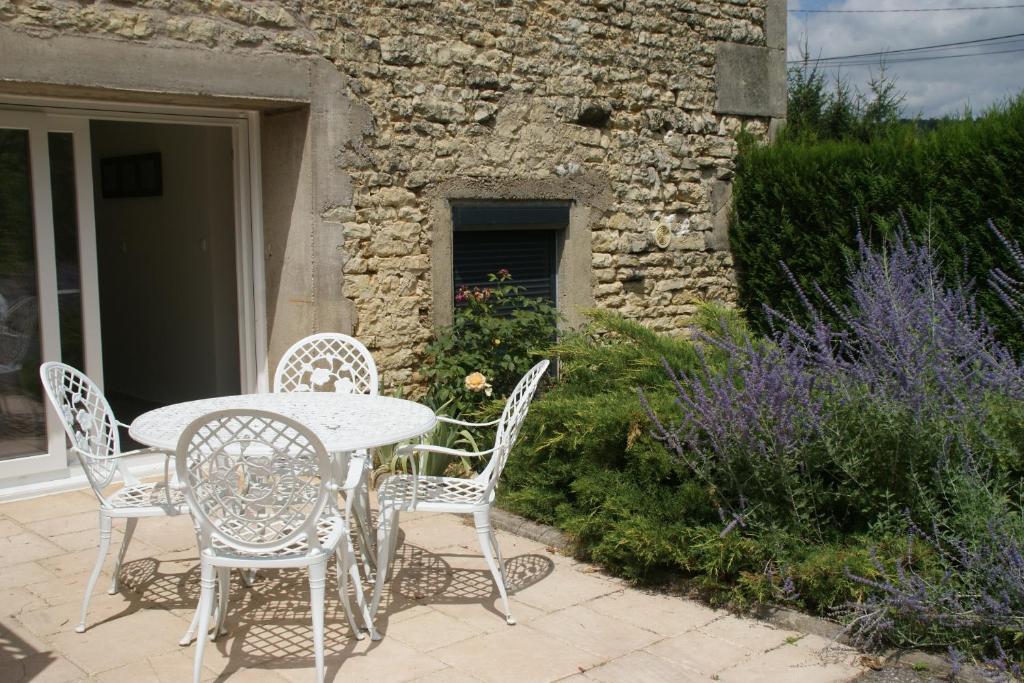 una mesa y sillas en un patio en La Goélette en Bazincourt-sur-Saulx