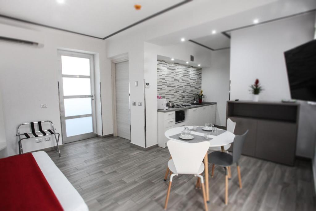 a kitchen and living room with a white table and chairs at Le colombe di Venere in Trapani