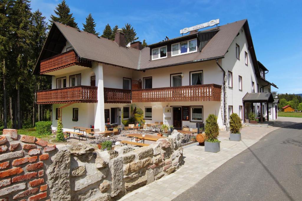 una grande casa con un muro di pietra di fronte di Gasthof Pension Waldfrieden a Brand