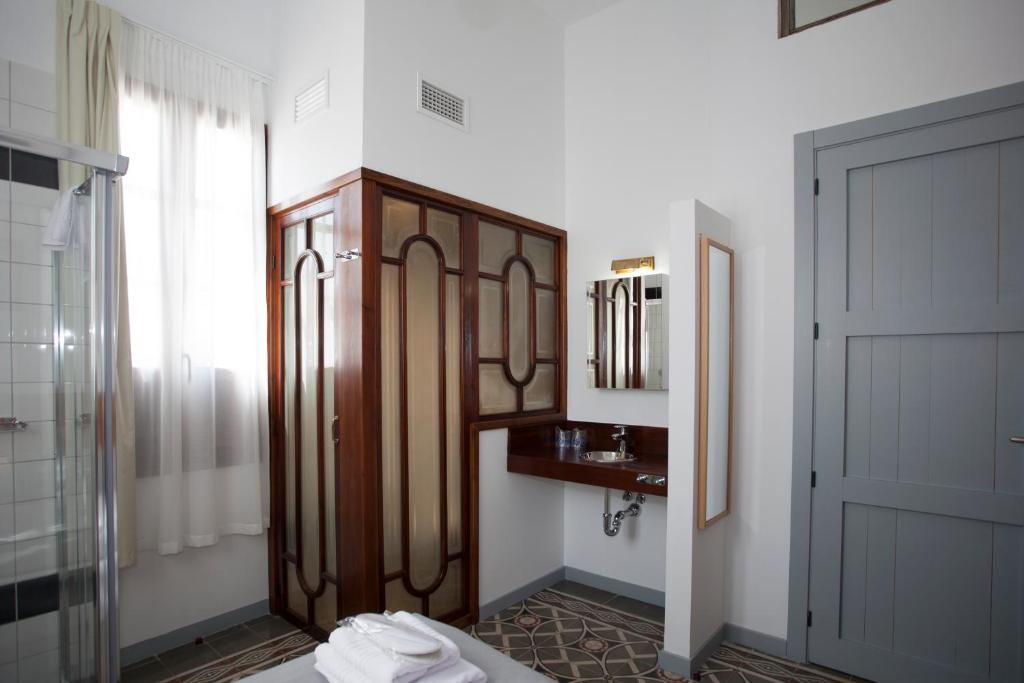 bagno con doccia, lavandino e specchio di Gran H La Marina ad Altea