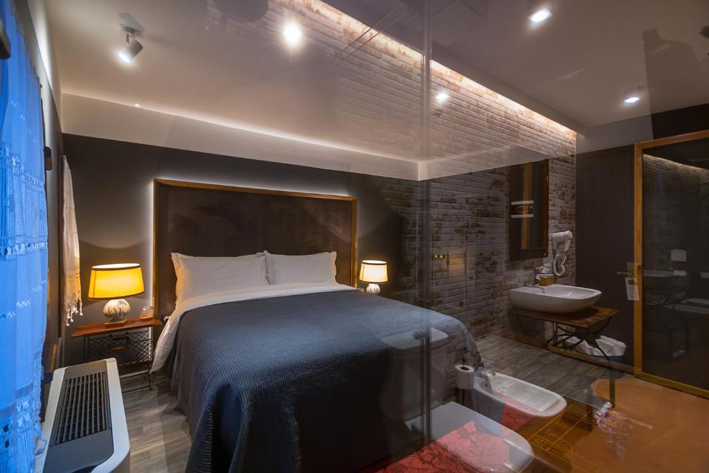 um quarto com uma cama e uma casa de banho com um lavatório em HANI I PAZARIT Boutique Hotel em Korçë