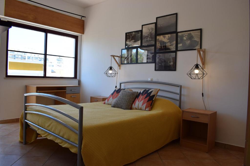 a bedroom with a yellow bed with two pillows at Casa da Baixa in Faro