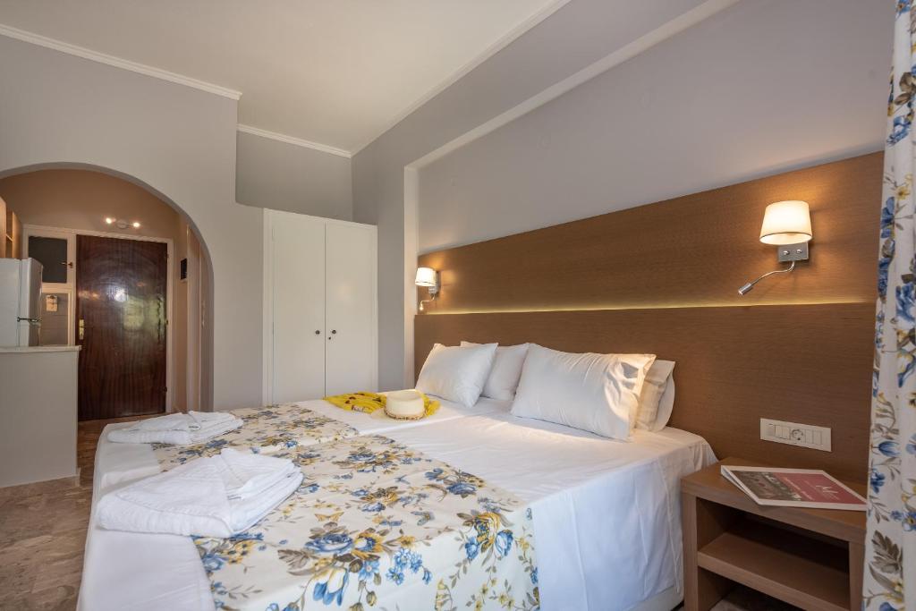 een hotelkamer met een groot bed met witte lakens bij Maria Studios in Kerion