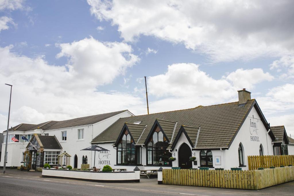 a white building with a black roof at Inn On The Coast in Portrush