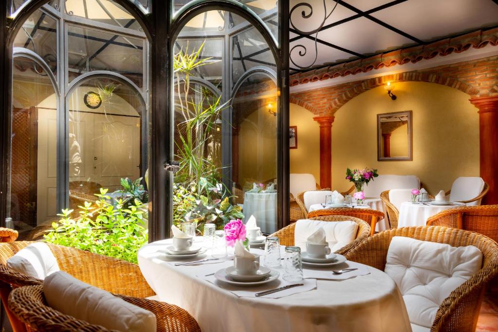 un restaurant avec des tables et des chaises blanches et une terrasse dans l'établissement Hôtel Playa, à Saint-Tropez