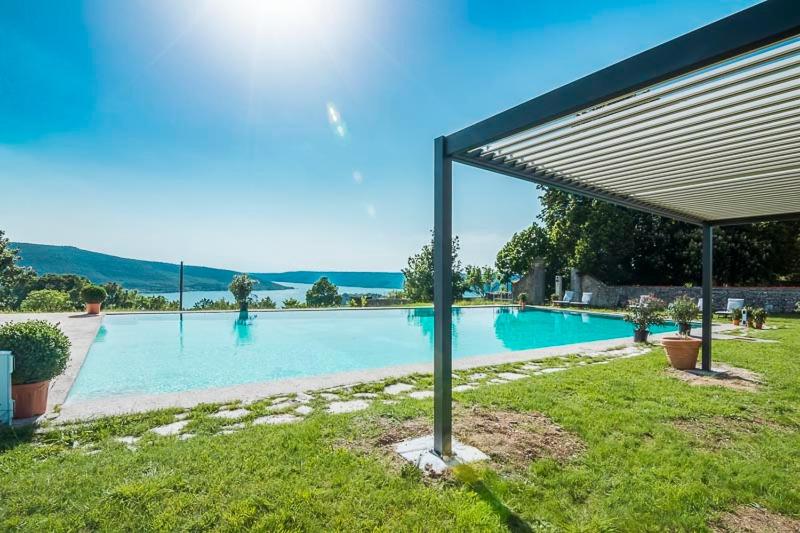a large swimming pool with a shade in a yard at Chambre d'hotes - Ferme de Chanteraine in Aiguines