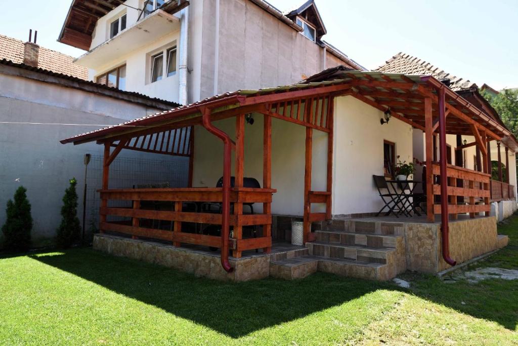 una pérgola de madera en el lateral de una casa en Casa Optim, en Călimăneşti