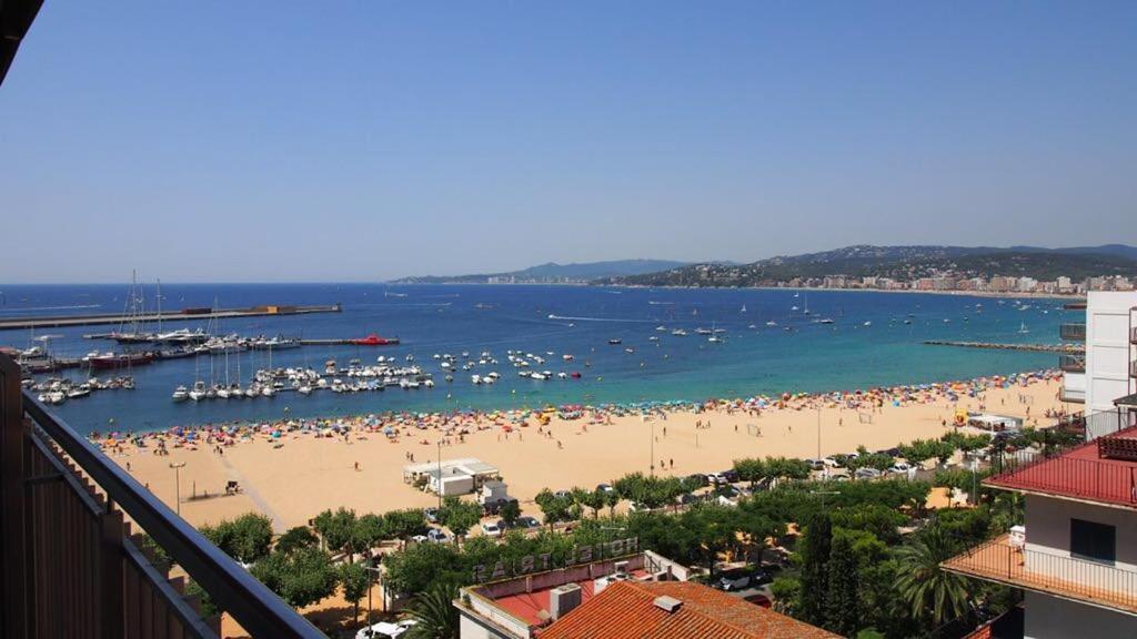 a beach with a bunch of people in the water at Seafront Apartment in Palamós in Palamós