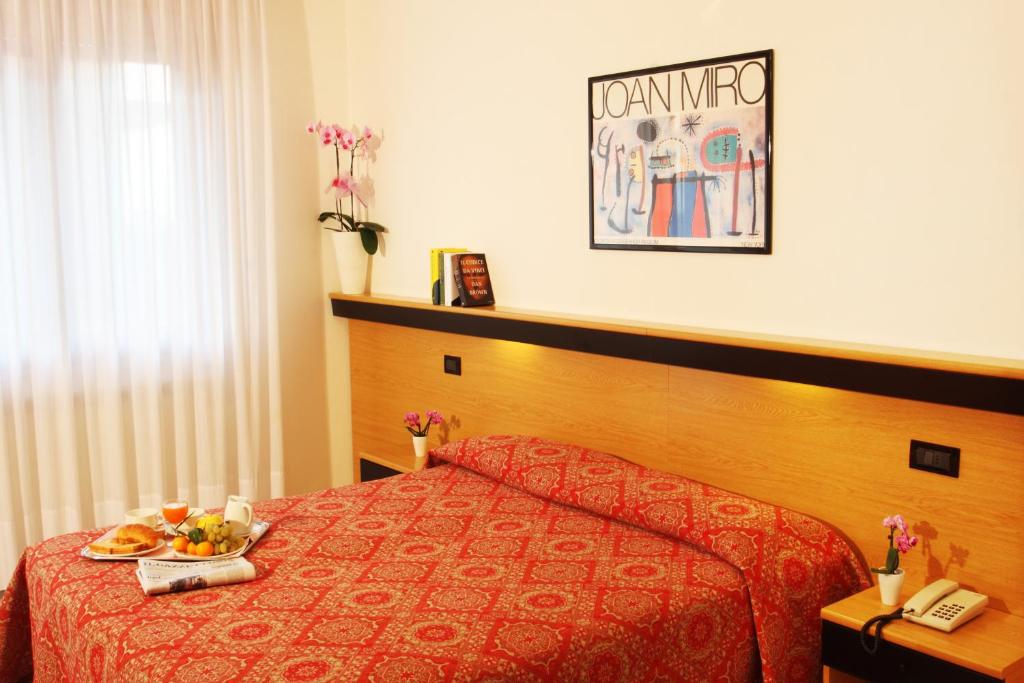 een hotelkamer met een bed met een bord eten erop bij Hotel Colorado in Sottomarina