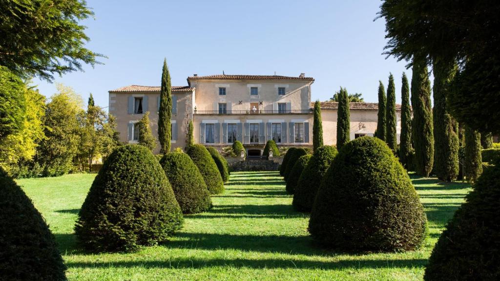 un jardín con árboles y un gran edificio en Villa-A en Rouillac