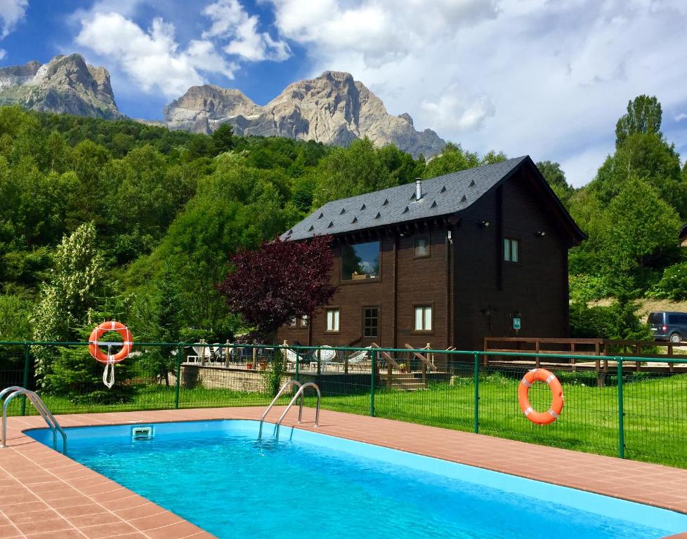 a house with a swimming pool in front of a mountain at Piedrafita Mountain in Piedrafita de Jaca