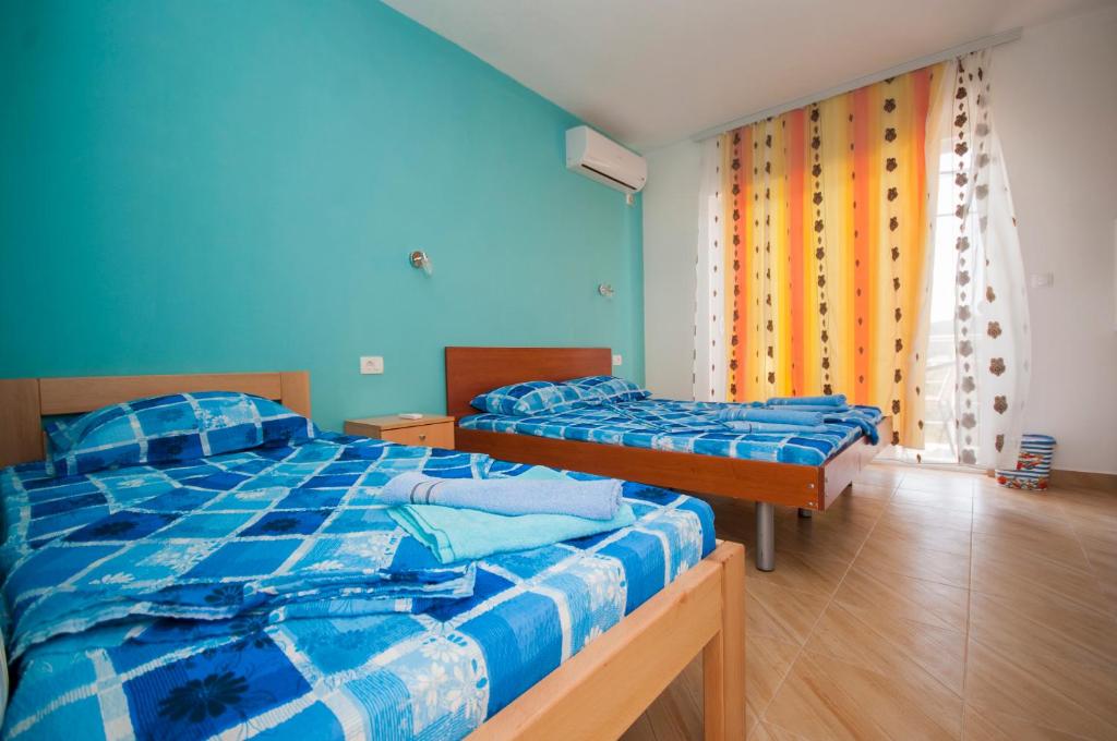 2 aparte bedden in een kamer met blauwe muren bij Studio Apartments Tea in Sutomore