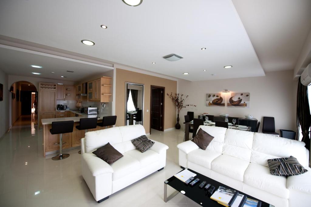 ein Wohnzimmer mit 2 weißen Sofas und einer Küche in der Unterkunft Zerniq Misrah Simar in Qala