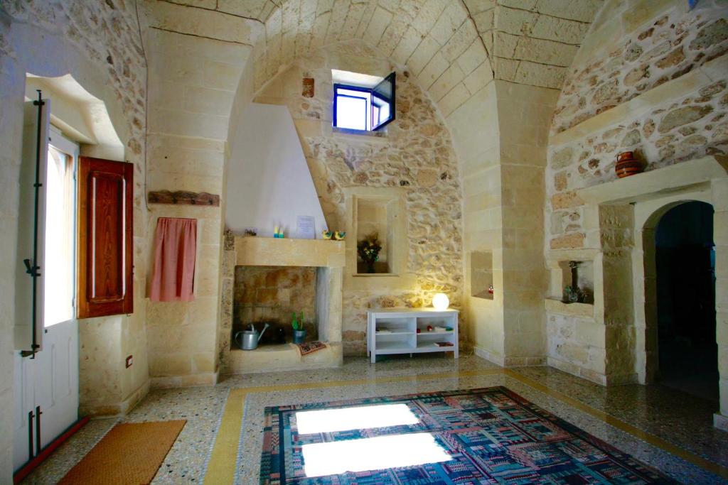 a large room with a fireplace and a stone wall at Dimora Storica San Giovanni in Zollino