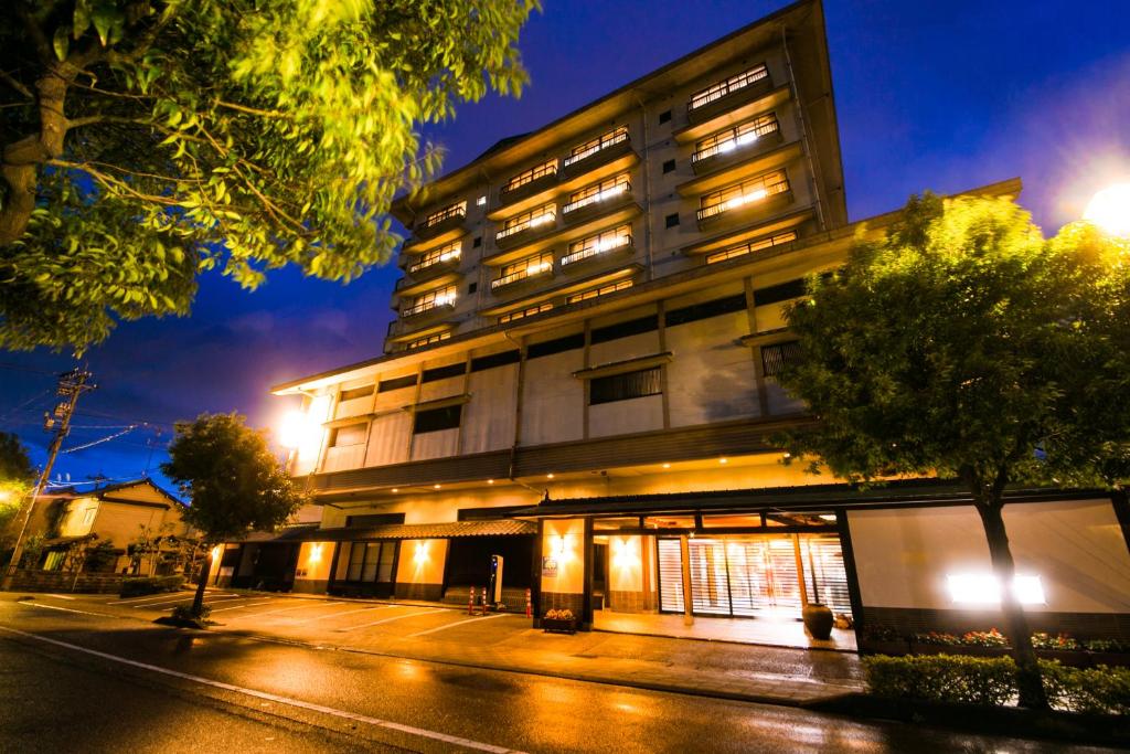 加賀的住宿－加賀之宿寶生亭旅館，夜幕降临的城市街道上一座高楼