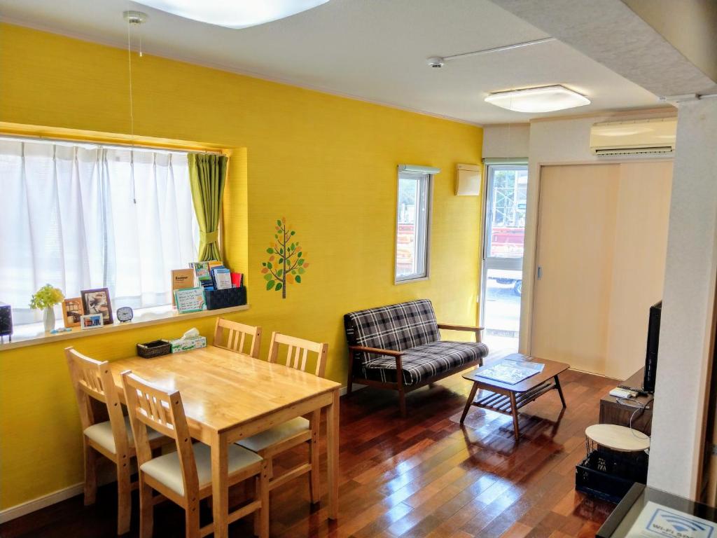 a dining room with a table and a chair at Duplex Makishi in Makishimachi