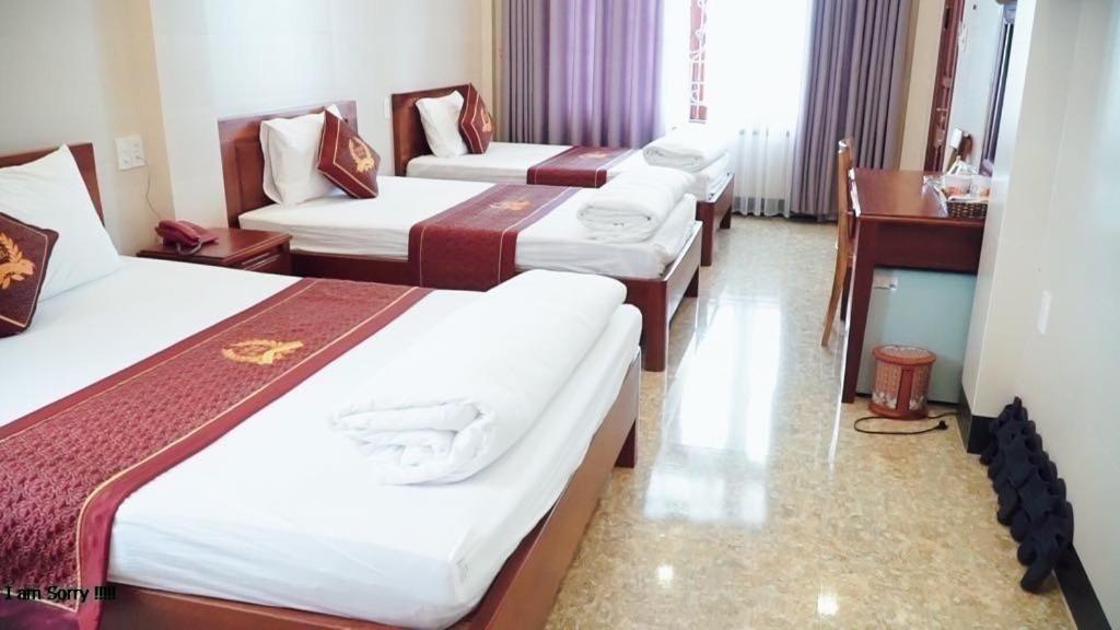 a hotel room with three beds and a desk at Victor Hotel in Tiền Tiệp