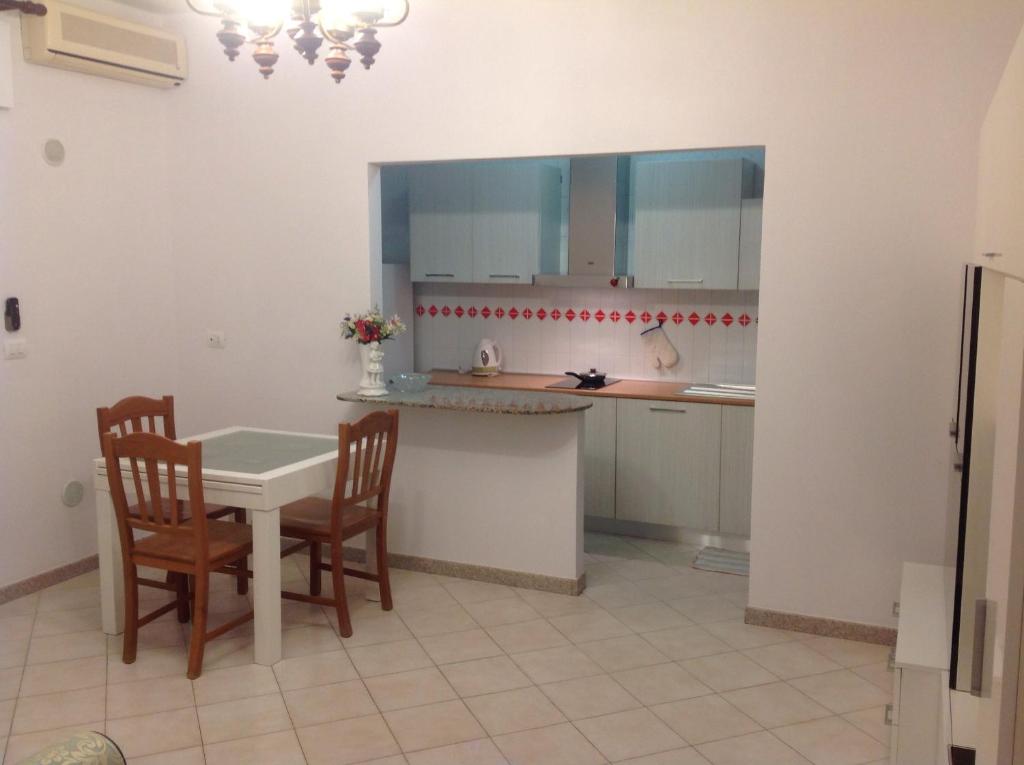 a kitchen with a table and two chairs and a table at Appartamento al mare Puglia in Ginosa Marina
