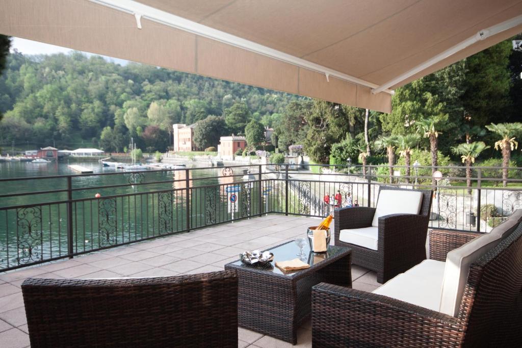 a balcony with chairs and a table and a view of the water at Il Golfo Apartment in Lenno