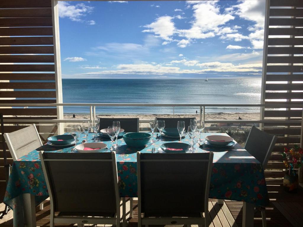 a dining table with a view of the ocean at Meuble de tourisme classé, climatisation, pieds dans l'eau in Palavas-les-Flots
