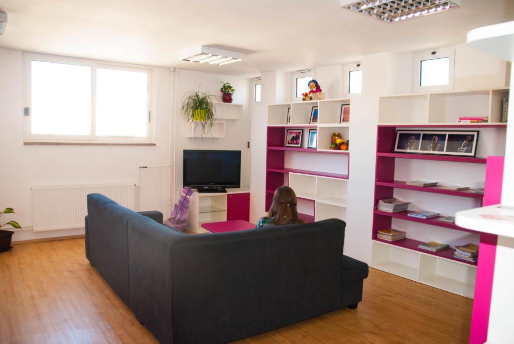 a living room with a couch and a tv at Split Summer Budget Rooms in Split