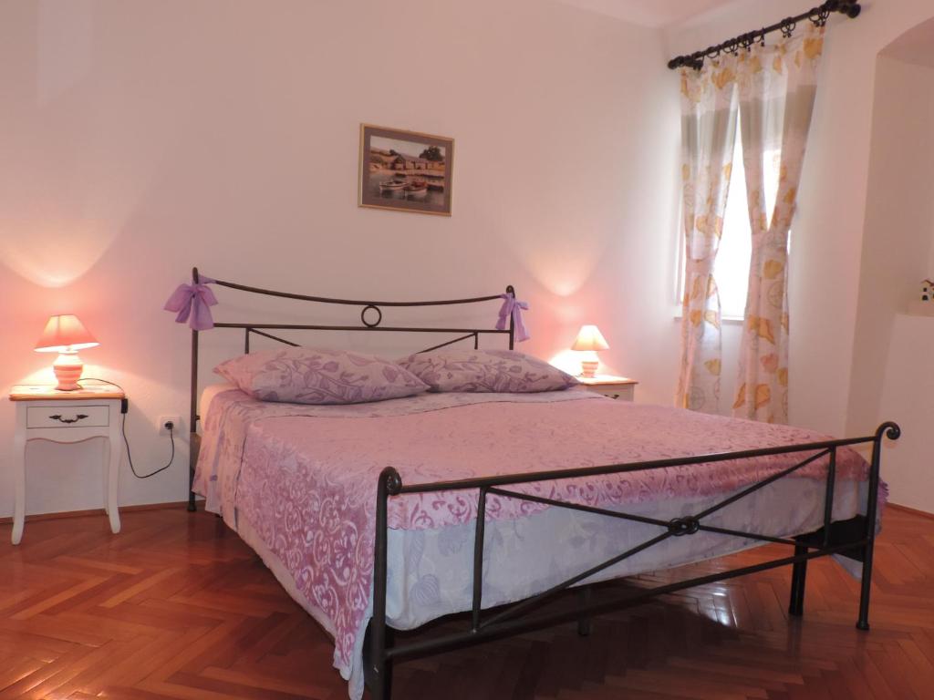 een slaapkamer met een bed met een roze sprei bij Apartment Pera in Split