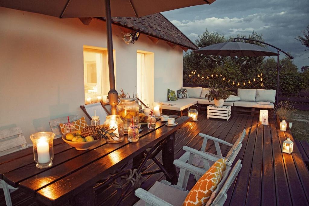 a wooden table on a deck with an umbrella at Domek na Zwierzynieckim Rogu in Trygort