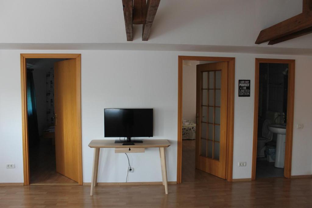 a television on a table in a room with two doors at News Apartment in Bucharest