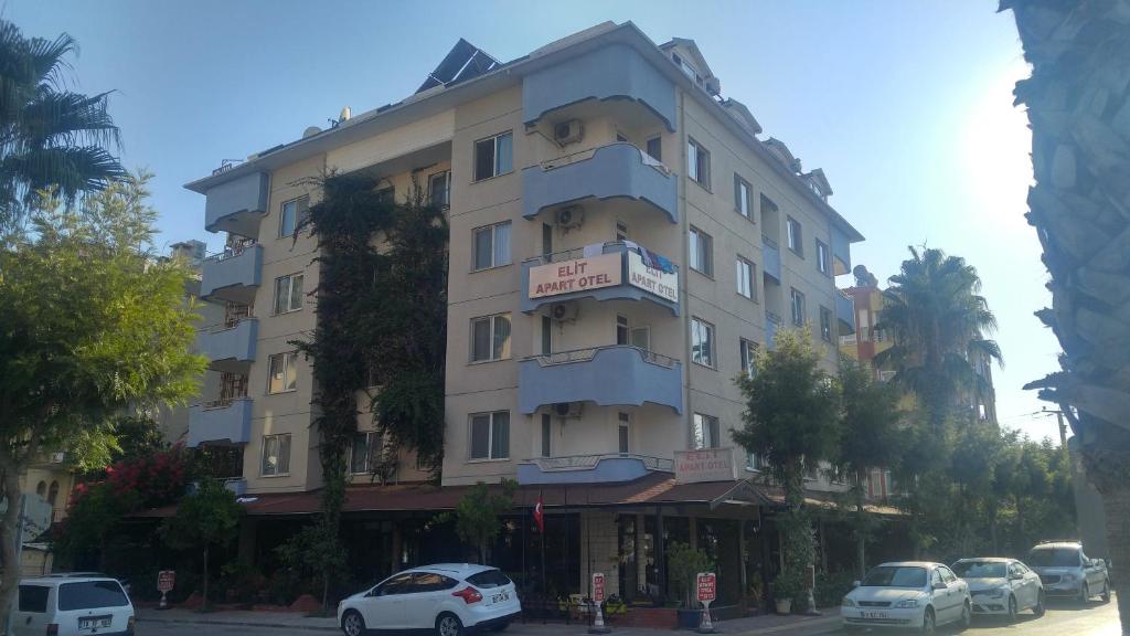 un edificio alto con coches estacionados frente a él en Elit Apart Otel, en Konaklı
