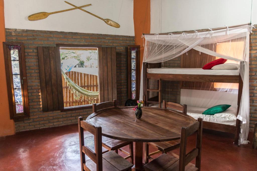 uma sala de jantar com uma mesa e 2 beliches em Casas do San Caraíva - Turma em Caraíva