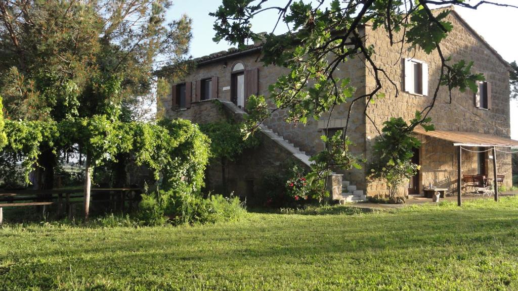 una antigua casa de piedra con un patio de césped en Casale Gatta Morena, en Pianiano