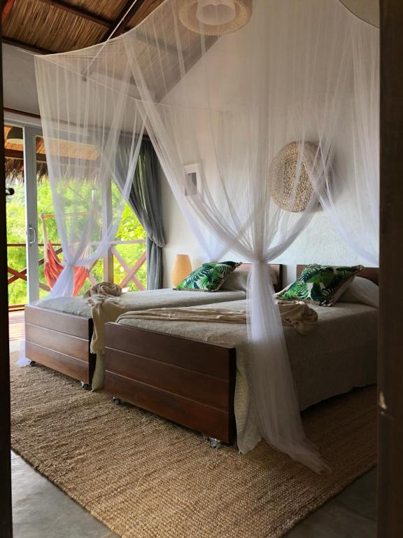 a bedroom with a canopy bed with mosquito nets at Reserva Natural Tierra Adentro in Minca