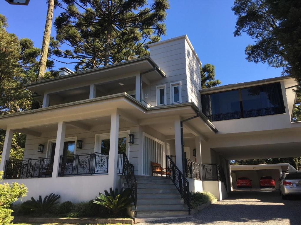 una grande casa bianca con portico di Residencial Jardim dos Pinheiros B a Canela