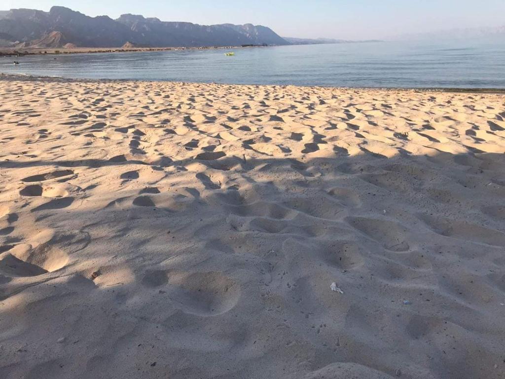 a sandy beach with footprints in the sand at Aquarium Camp in Nuweiba