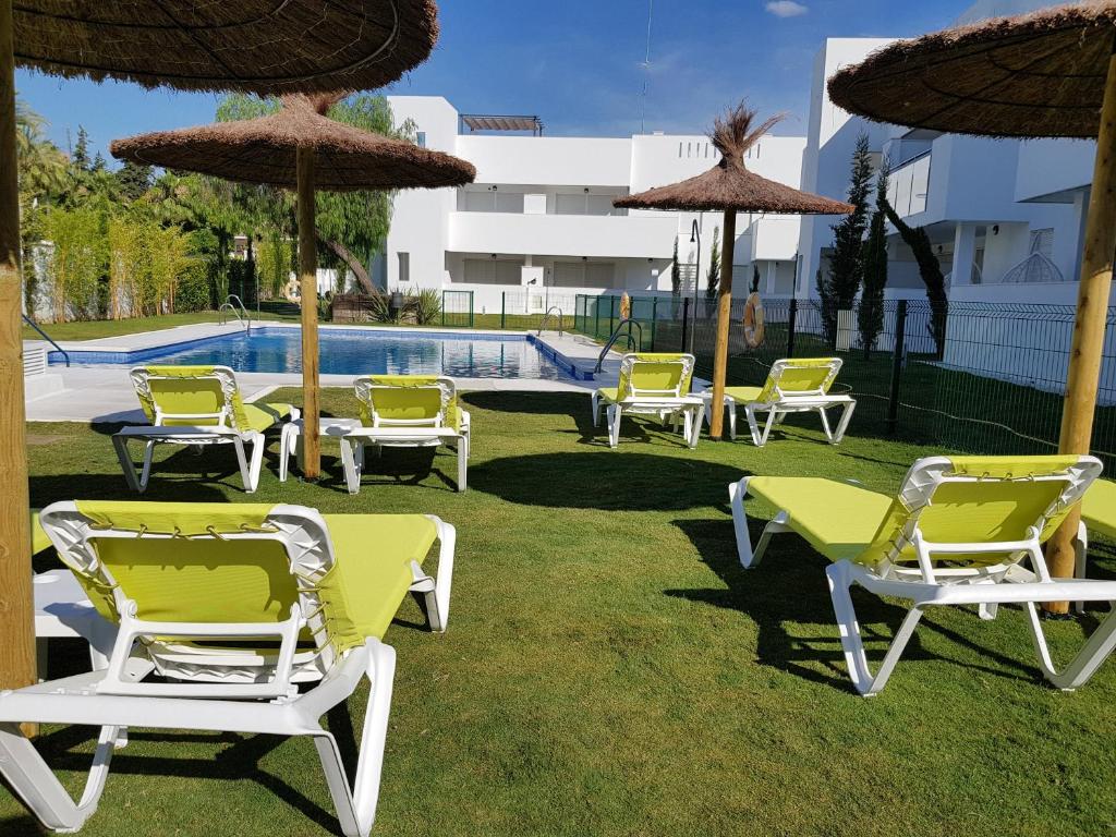 a group of chairs and umbrellas next to a pool at La Reserva Puerto Banus in Marbella