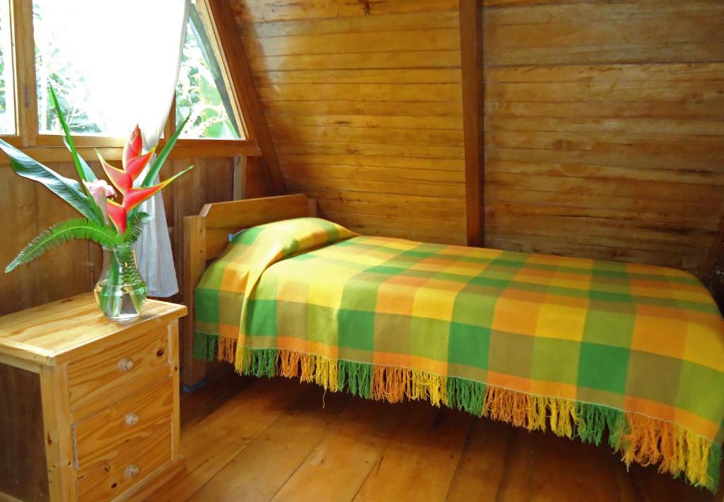Postel nebo postele na pokoji v ubytování Cabañas Armonía y Jardín de Orquídeas
