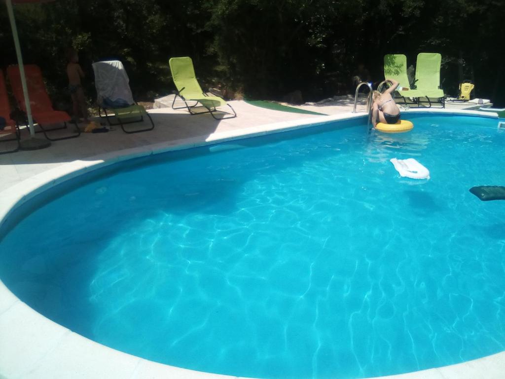 a large blue swimming pool with a person in a toy at Apartments Bosket in Kastav
