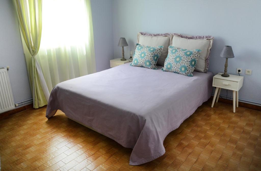 1 dormitorio con 1 cama grande con almohadas y ventana en Villa Avly, en Máleme