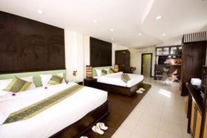 ein großes Schlafzimmer mit 2 Betten und einem Sofa in der Unterkunft Royal Nakara Ao Nang in Ao Nang Beach