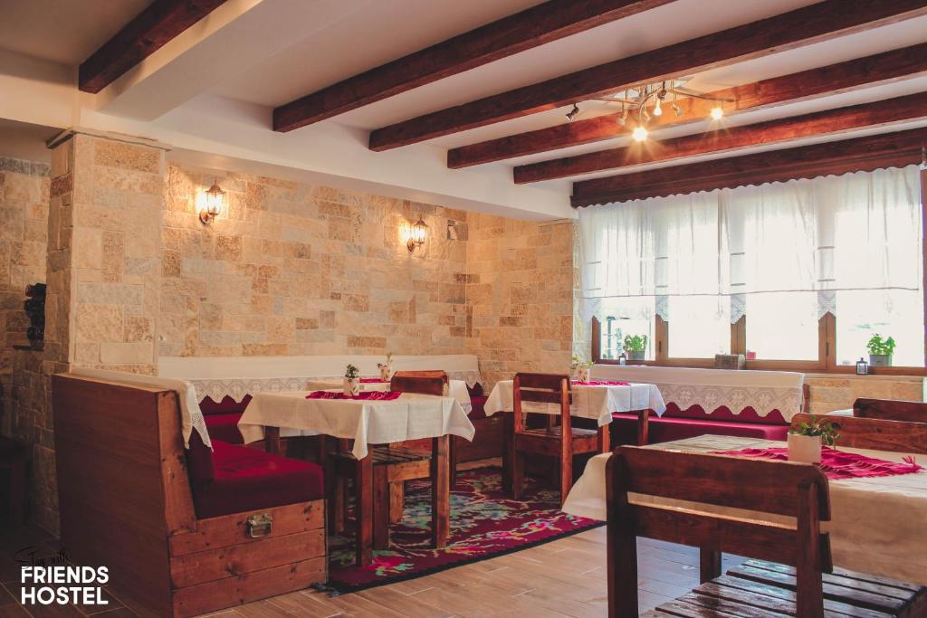 - un restaurant avec des tables et des chaises dans une salle dans l'établissement Friends' Guesthouse & Hostel, à Gjirokastër