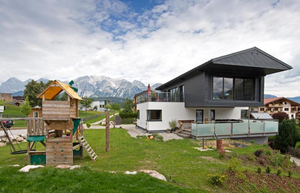 a home with a playground and a house at Haus Mozart in Schladming
