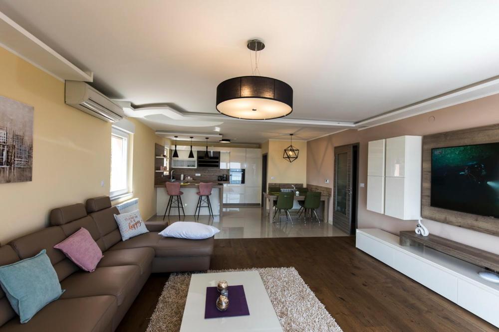 - un salon avec un canapé et une télévision dans l'établissement Apartments Sandra with free private parking, à Rijeka