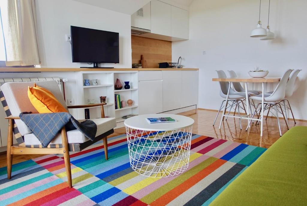 a living room with a table and a colorful rug at Apartments Milic in Kaludjerske Bare